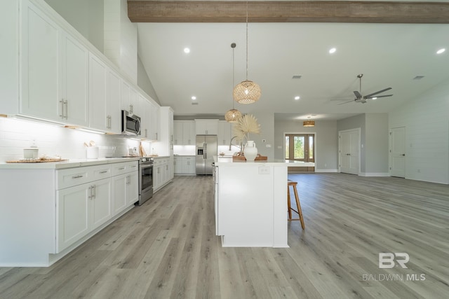11341 Tall Timber Ln, Elberta, AL 36530 - kitchen featuring stainless steel appliances, a breakfast bar area, open floor plan, light wood finished floors, and white cabinetry