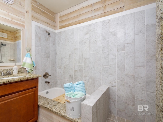 bathroom featuring tiled shower / bath combo and vanity