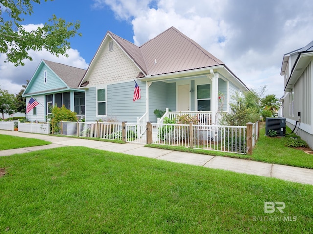 view of front of house featuring a front lawn, covered porch, and central AC