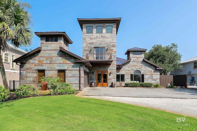 view of front of property featuring a balcony and a front lawn