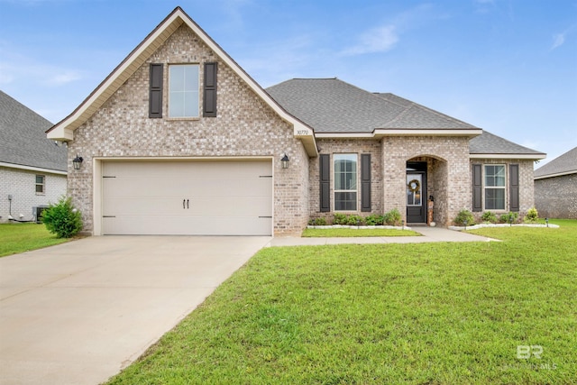 view of front of house with driveway, a front lawn, central AC, roof with shingles, and brick siding