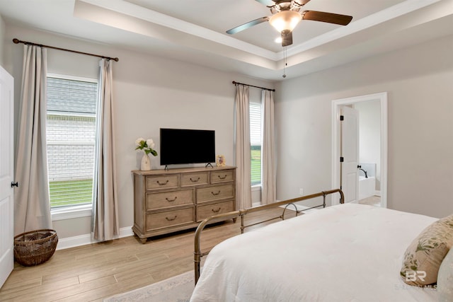 bedroom featuring a raised ceiling, ceiling fan, and light wood-type flooring