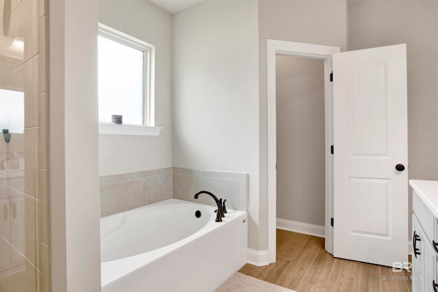 bathroom featuring a tub to relax in, vanity, and wood-type flooring