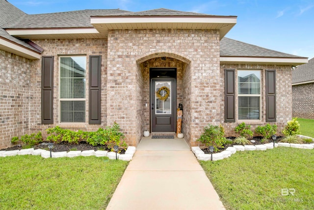 property entrance with a lawn