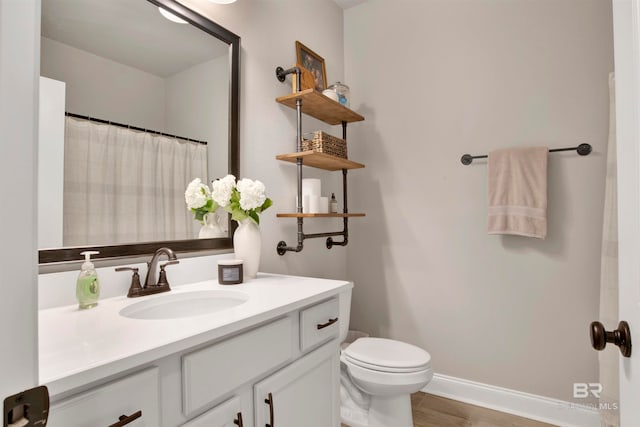 bathroom featuring toilet, hardwood / wood-style flooring, and vanity