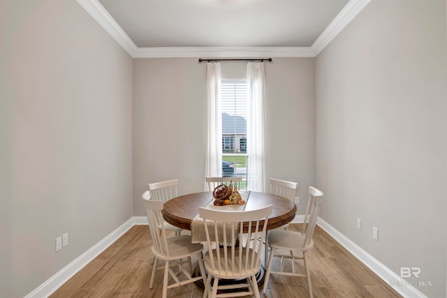 dining space with light wood-type flooring and crown molding