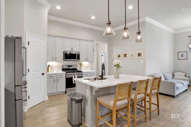 kitchen featuring white cabinetry, stainless steel appliances, sink, a center island with sink, and light hardwood / wood-style floors