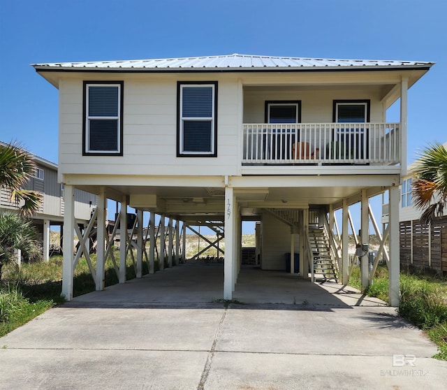 1757 W Beach Blvd, Gulf Shores, AL 36542 - raised beach house featuring stairs, a carport, concrete driveway, and metal roof