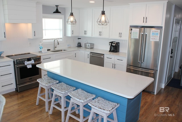 1757 W Beach Blvd, Gulf Shores, AL 36542 - kitchen with stainless steel appliances, a sink, a kitchen bar, dark wood-type flooring, and recessed lighting