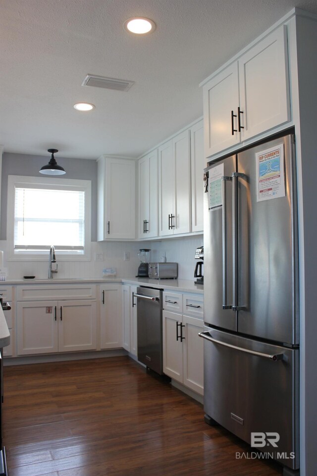 1757 W Beach Blvd, Gulf Shores, AL 36542 - kitchen featuring appliances with stainless steel finishes, a sink, white cabinetry, light countertops, and dark wood-style flooring