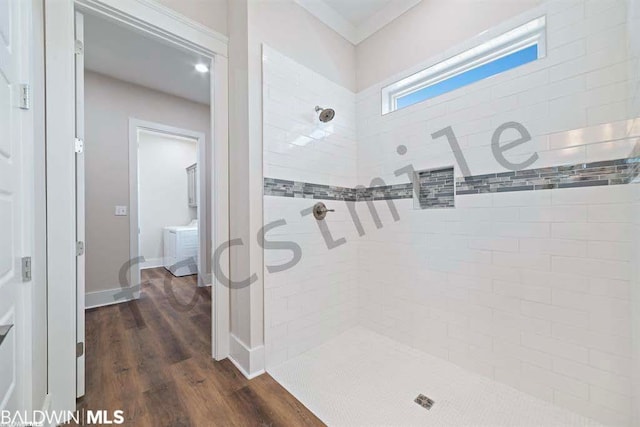 bathroom with hardwood / wood-style flooring and tiled shower