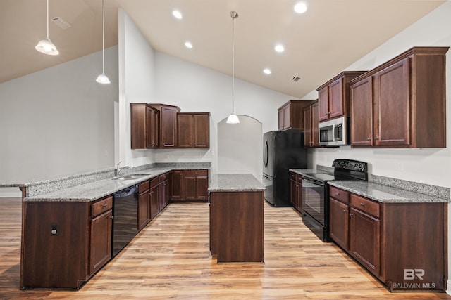kitchen with pendant lighting, light wood-type flooring, a kitchen island, and black appliances