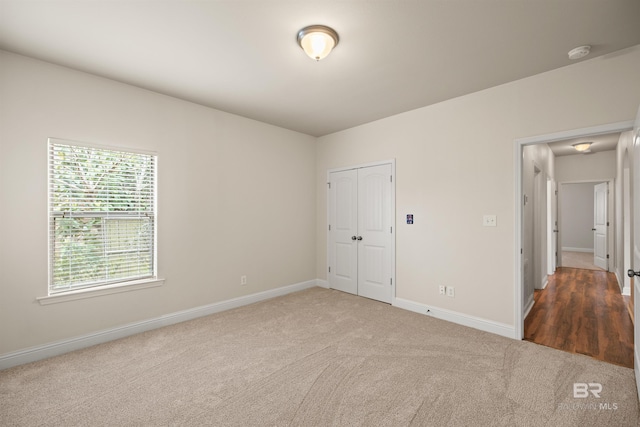 unfurnished bedroom with carpet flooring and a closet