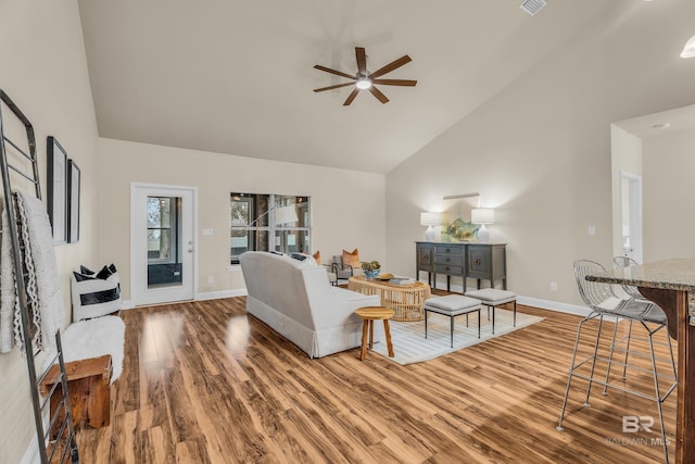 living room with ceiling fan, wood-type flooring, and high vaulted ceiling