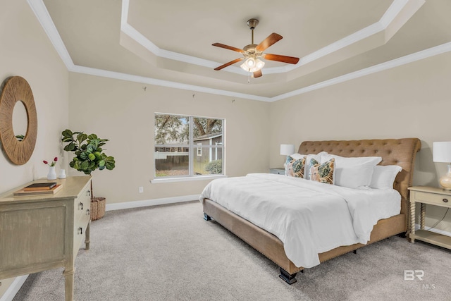carpeted bedroom featuring crown molding, ceiling fan, and a tray ceiling