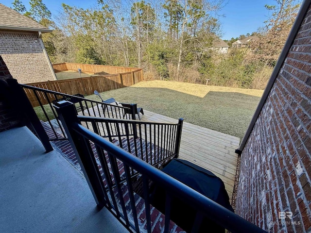 wooden terrace with a fenced backyard and a lawn