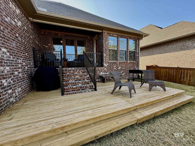 wooden deck featuring fence and a grill