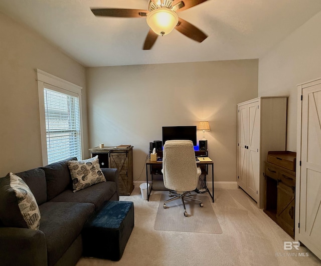 home office featuring light carpet, ceiling fan, and baseboards