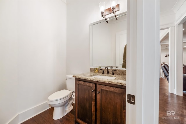 bathroom with hardwood / wood-style flooring, toilet, and vanity