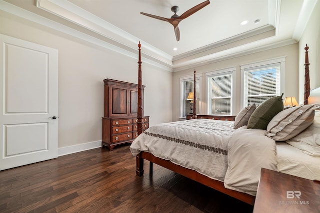 bedroom featuring ceiling fan, dark hardwood / wood-style floors, a tray ceiling, and ornamental molding