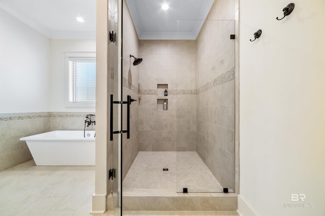 bathroom featuring independent shower and bath, tile patterned floors, ornamental molding, and tile walls