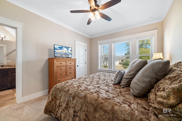 bedroom featuring ceiling fan, light colored carpet, crown molding, and ensuite bath