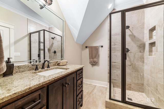 bathroom featuring an enclosed shower, vanity, and lofted ceiling