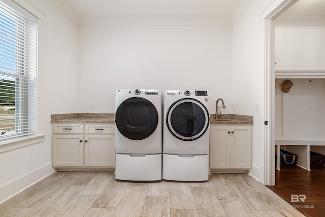 clothes washing area with sink, independent washer and dryer, cabinets, and ornamental molding