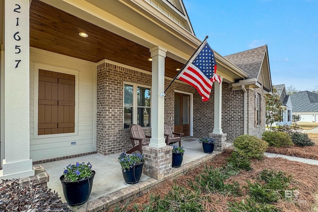 view of exterior entry featuring covered porch