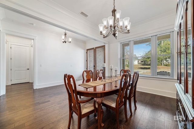 dining room with crown molding, dark hardwood / wood-style flooring, a healthy amount of sunlight, and an inviting chandelier