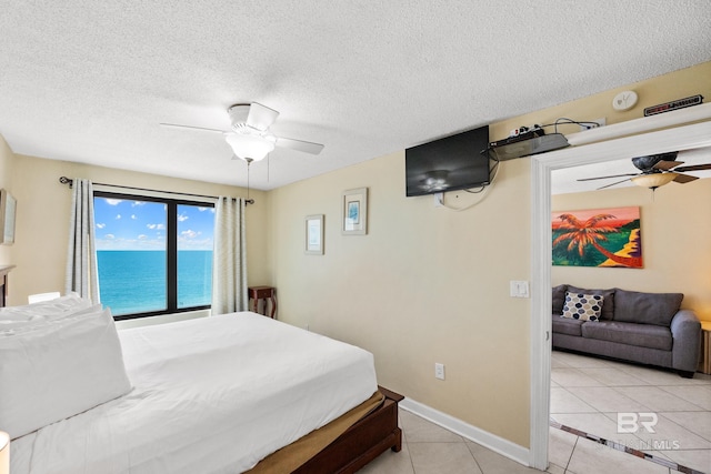 bedroom with light tile patterned flooring, baseboards, a textured ceiling, and ceiling fan