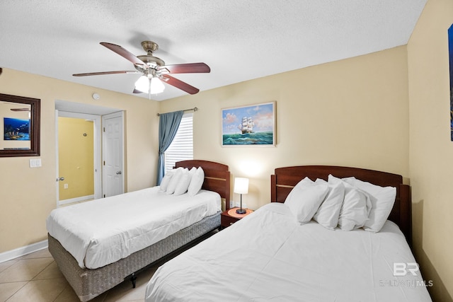 bedroom with tile patterned floors, baseboards, a textured ceiling, and ceiling fan