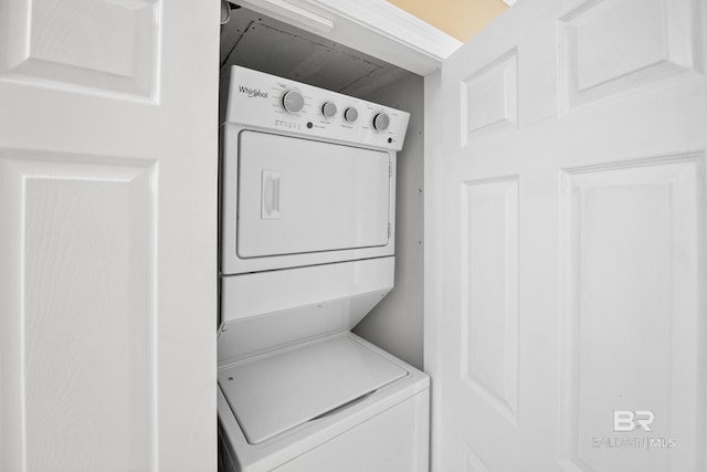 clothes washing area with stacked washer and clothes dryer and laundry area