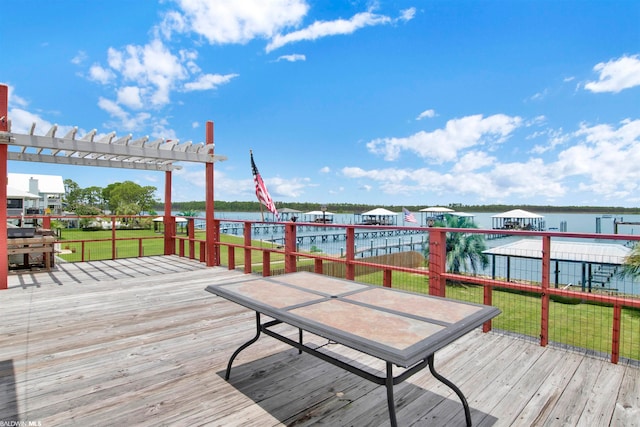 wooden terrace featuring a water view and a lawn