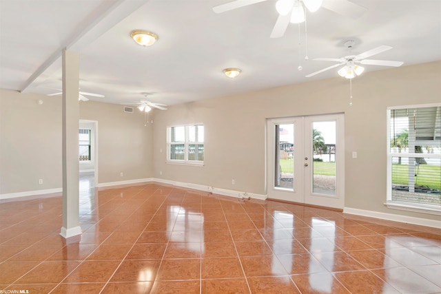 spare room featuring light tile flooring, ceiling fan, french doors, and a wealth of natural light