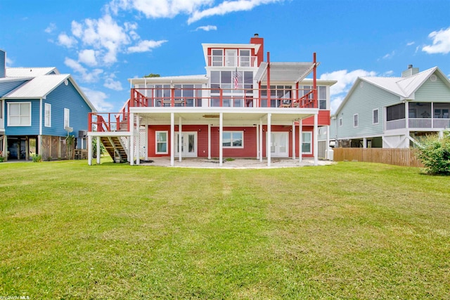 back of property with a wooden deck and a lawn