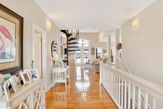 corridor featuring an inviting chandelier, light hardwood / wood-style floors, and french doors