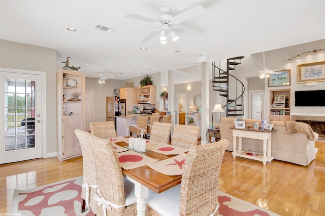 dining space with ceiling fan and light wood-type flooring