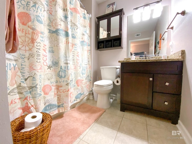 bathroom featuring toilet, vanity, and tile patterned floors