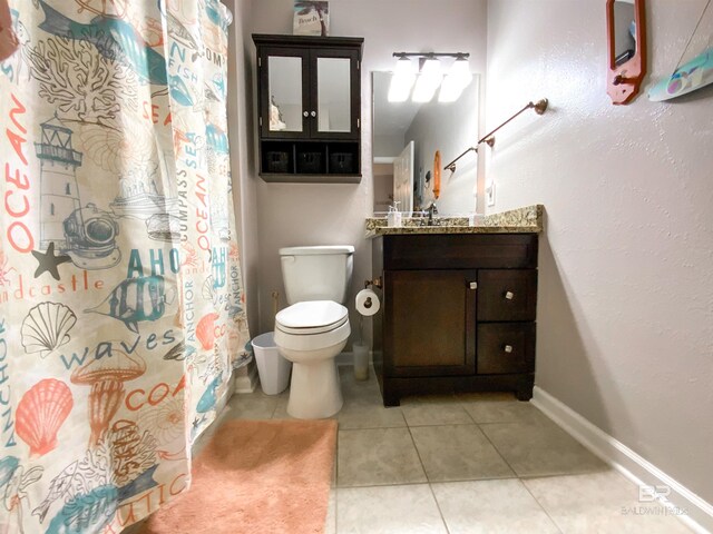 bathroom with toilet, tile patterned flooring, and vanity