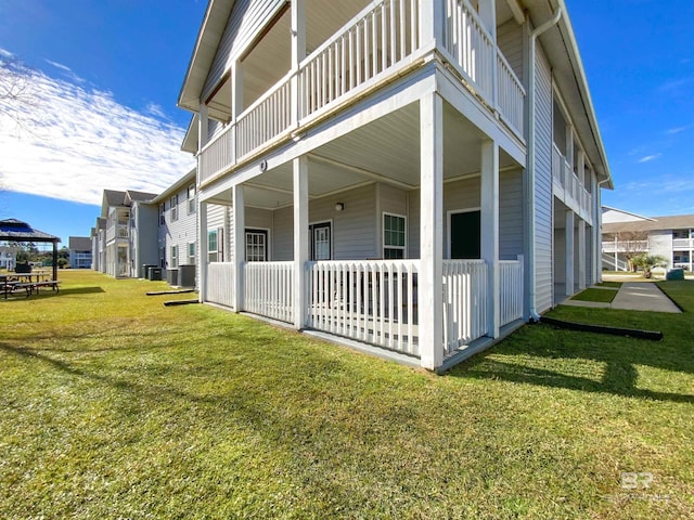 view of side of home featuring a gazebo, a yard, and central AC unit