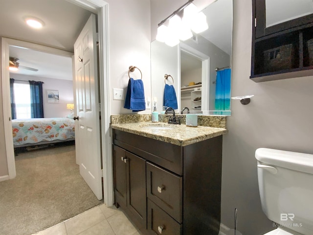 bathroom with toilet, vanity, tile patterned floors, and ceiling fan