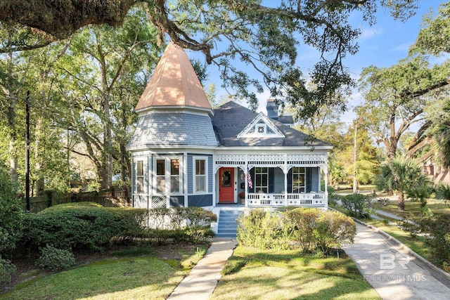 victorian house featuring a front lawn and covered porch