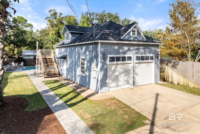 garage with a lawn and a fenced in pool