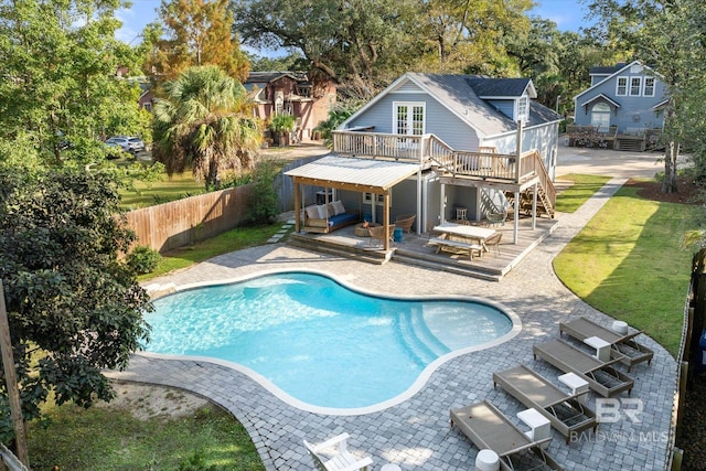 view of pool featuring a lawn, a patio, and a deck