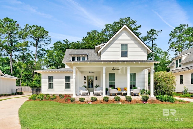 modern farmhouse with a front yard, ceiling fan, and a porch