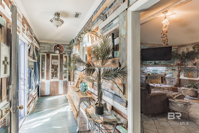 hall featuring tile patterned flooring, a wealth of natural light, and crown molding