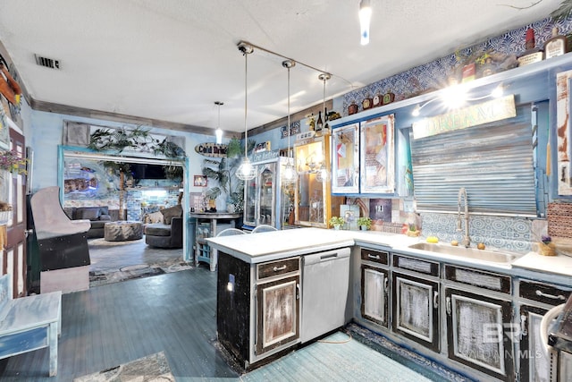 kitchen with pendant lighting, a textured ceiling, sink, kitchen peninsula, and stainless steel dishwasher