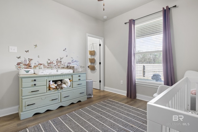 bedroom featuring dark hardwood / wood-style flooring and a crib