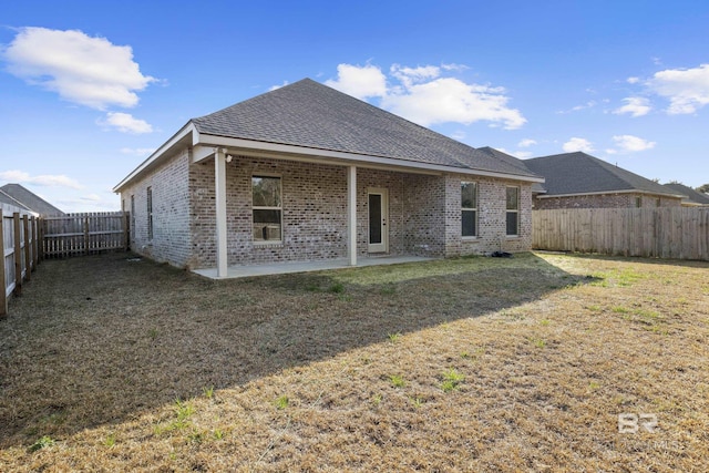 back of property featuring a patio and a lawn